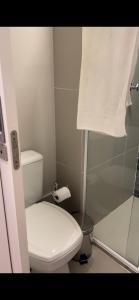 a bathroom with a toilet and a shower and a towel at Estanconfor Santos 705 com estacionamento GRÁTIS in Santos