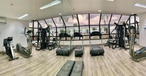 un gimnasio con equipo cardiovascular y una gran pared de cristal en Flat Millennium - Suíte 809, en Manaus