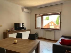 sala de estar con mesa y ventana en Domus Iuturnae en Castel Gandolfo