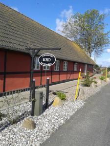 un panneau komo sur le côté d'un bâtiment dans l'établissement Jungshoved Kro B&B, à Præstø