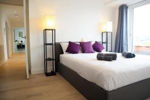 a bedroom with a large bed with purple pillows at Penthouse by the Ipswich Station in Ipswich