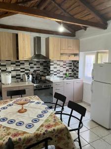 a kitchen with a table and chairs and a white refrigerator at Rodovani Cottage in Antipaxos