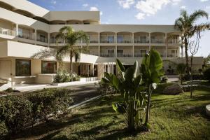 an exterior view of a building with palm trees at Domes Aulūs Zante, All Inclusive, Autograph Collection in Laganas