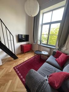 a living room with a couch and a red rug at M Loft2 in Kaunas