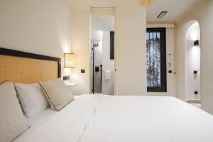 een slaapkamer met een groot wit bed met witte kussens bij Oso Madrid Studios in Madrid