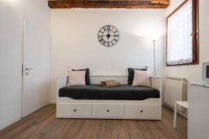sypialnia z łóżkiem z zegarem na ścianie w obiekcie Suite Ravà - San Marco with pool w Wenecji