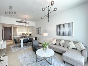 a living room with a couch and a table at Mira Holiday Homes - Newly 2 bedroom in Dubai Marina with Canal View in Dubai