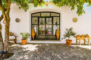 uma entrada para um edifício com uma porta de vidro em Cortijo El Indiviso em Vejer de la Frontera