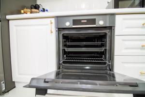 an oven with its door open in a kitchen at AB Apart Business 64305 in Astana