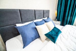 a bed with blue and white pillows on it at AB Apart Business 64305 in Astana