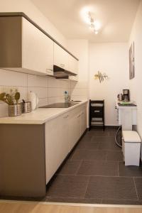 uma cozinha com armários brancos e uma bancada em Wohnperle Birkwitzer Stübchen em Pirna