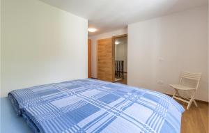 a bedroom with a blue comforter on a bed at 2 Bedroom Awesome Home In Podgorje in Podgorje