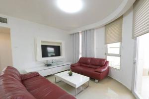 a living room with a red couch and a tv at Modern 2BR APT Golf Residence in Eilat