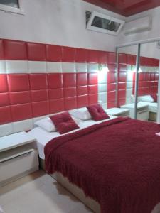 ein rot-weißes Schlafzimmer mit einem Bett und einem Spiegel in der Unterkunft Гостевой дом ЛОНТАНА in Gagra