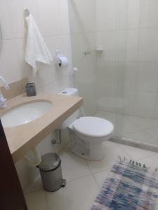 a bathroom with a white toilet and a sink at Recanto dos Irmãos in Itaúnas