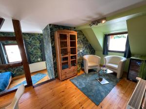 ein Wohnzimmer mit grünen Wänden sowie einem Tisch und Stühlen in der Unterkunft Hotel Garni Maaß in Braubach