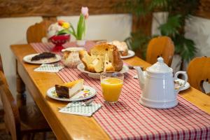 a table with a breakfast of bread and orange juice at Chez l'Alsacien - Gîte authentique de charme classé 4 étoiles in Barr