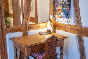 un piccolo tavolo in legno con lampada e sedia di Chez l'Alsacien - Gîte authentique de charme classé 4 étoiles a Barr