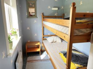 a bedroom with two bunk beds and a window at Red cozy cottage with sea view in Mörbylånga