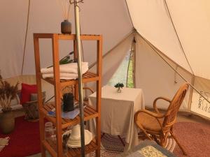 um quarto com uma tenda com uma mesa e uma cadeira em Helles Have Glamping em Stege
