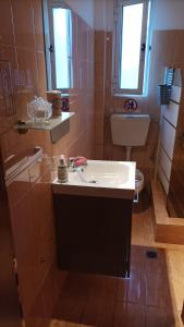 La salle de bains est pourvue d'un lavabo et de toilettes. dans l'établissement Dimitra Apartments, à Keramoti