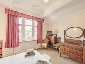 a bedroom with a bed and a dresser and a mirror at 15 Elms Road in Bare