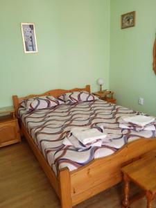 a bedroom with a large bed with a wooden frame at Къща за гости Ганчеви in Sozopol