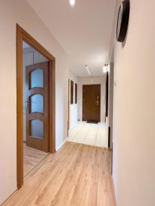 an empty hallway with a door and wooden floors at 15 Gdynia Centrum - Apartament mieszkanie dla 7 osób in Gdynia