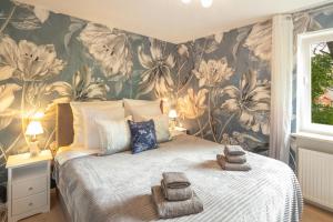 a bedroom with a large bed with a floral wallpaper at SweetHome - DAH03 - LUXUS PUR Apartment, Küche, TV in Dachau
