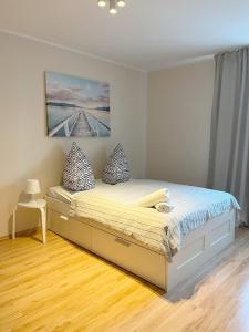 a bedroom with a large bed with pillows on it at 15 Gdynia Centrum - Apartament mieszkanie dla 7 osób in Gdynia
