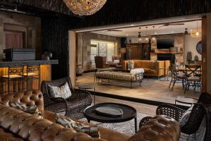 a living room with leather couches and a living room at Kruger Gate Hotel in Skukuza