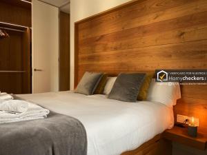 1 dormitorio con 1 cama grande y cabecero de madera en HomyAT Poeta Iglesias 1, Plaza Mayor, en Salamanca