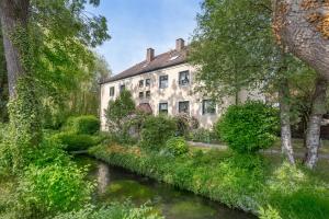 an old building with a river in front of it at SweetHome - DAH03 - LUXUS PUR Apartment, Küche, TV in Dachau