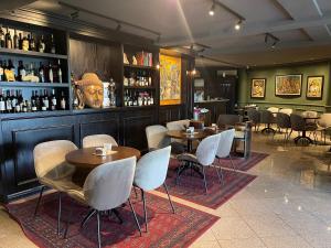 a restaurant with tables and chairs and a bar at Hotel Keto in Podgorica
