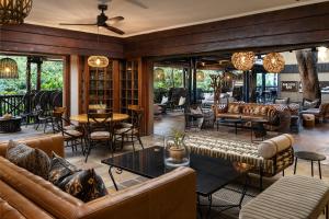 a living room with couches and tables and chairs at Kruger Gate Hotel in Skukuza +128 photos
