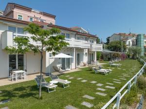 a building with a yard with chairs and tables at Agriturismo Terre degli Angeli in Pietra Ligure