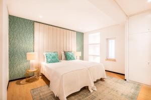 a bedroom with a large white bed with blue pillows at Pedro Mar in Albufeira