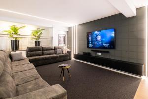 uma sala de estar com um sofá e uma televisão de ecrã plano em Pedro Mar em Albufeira