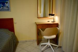 a bedroom with a desk with a chair and a mirror at EviaXL Guesthouse in Khrónia
