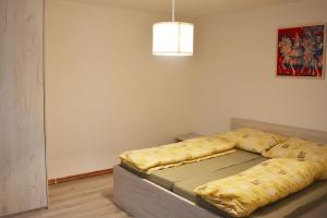 a bedroom with a bed with a yellow blanket at Apartmán Květinový Dům in Hluk