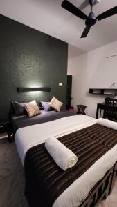 1 dormitorio con 1 cama grande y ventilador de techo en Sky Frame Beach Resort, en Varkala
