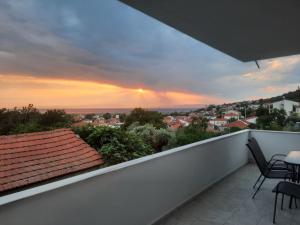 a balcony with a view of a city at sunset at Panorama Apartments in Prinos