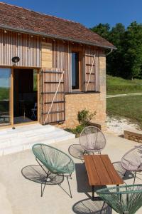 a patio with chairs and a bench and a building at Chambre d'hotes La Grange Milou in Beynac-et-Cazenac