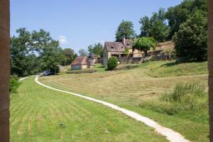 a winding road leading to a house on a hill at Chambre d'hotes La Grange Milou in Beynac-et-Cazenac