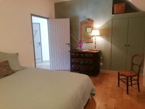 una camera da letto con un letto, uno specchio e una sedia di La Robinière Maison d'Hôtes a Mont-près-Chambord