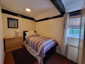 una piccola camera con letto e finestra di Otters' Lodge a Rooks Bridge