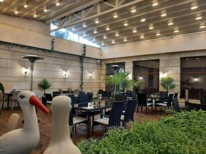 two swans standing in a restaurant with tables and chairs at Хотел Таганрог in Cherven Bryag