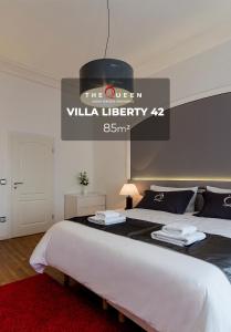 een slaapkamer met een groot bed met een bordje erop bij The Queen Luxury Apartments - Villa Liberty in Luxemburg