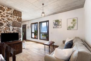 a living room with a couch and a tv at La Casa de Abajo in Valverde