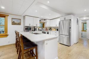 a kitchen with white cabinets and a stainless steel refrigerator at Ruby Creek Retreat in Port Orchard